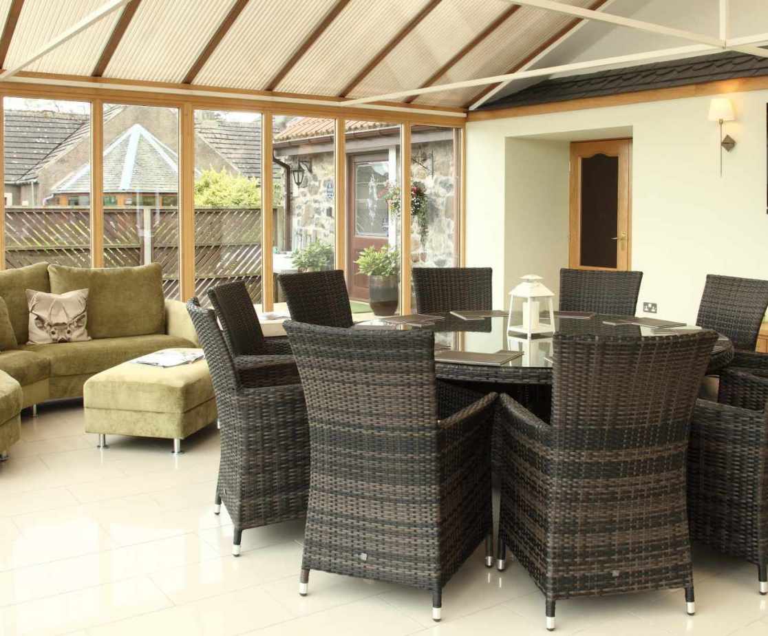 The spacious conservatory offers additional dining room or a wonderful space to gather for drinks