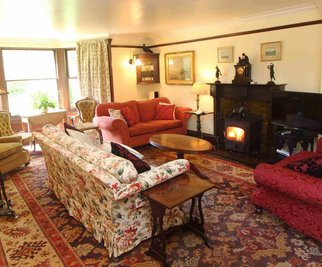 The wood-burning stove adds extra warmth to the spacious sitting room