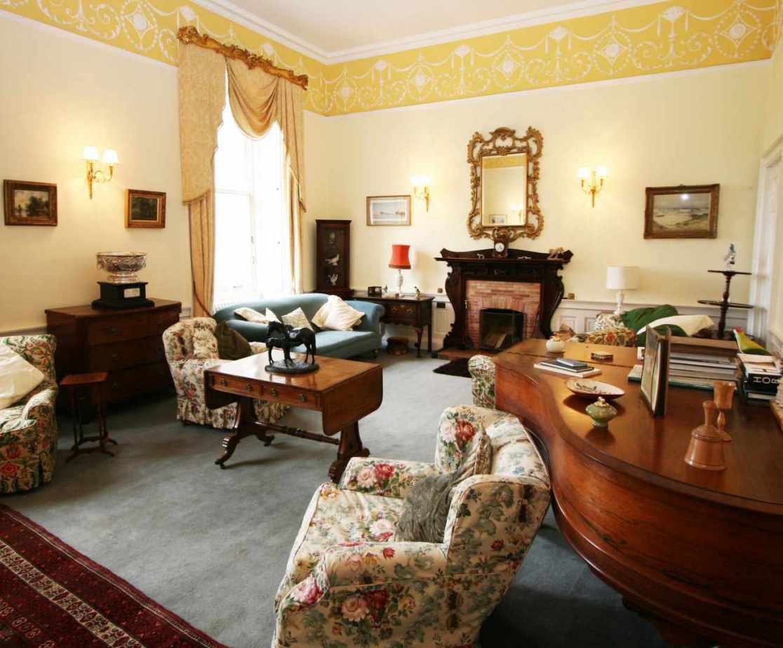 The large drawing room with an open fire feels like a family home