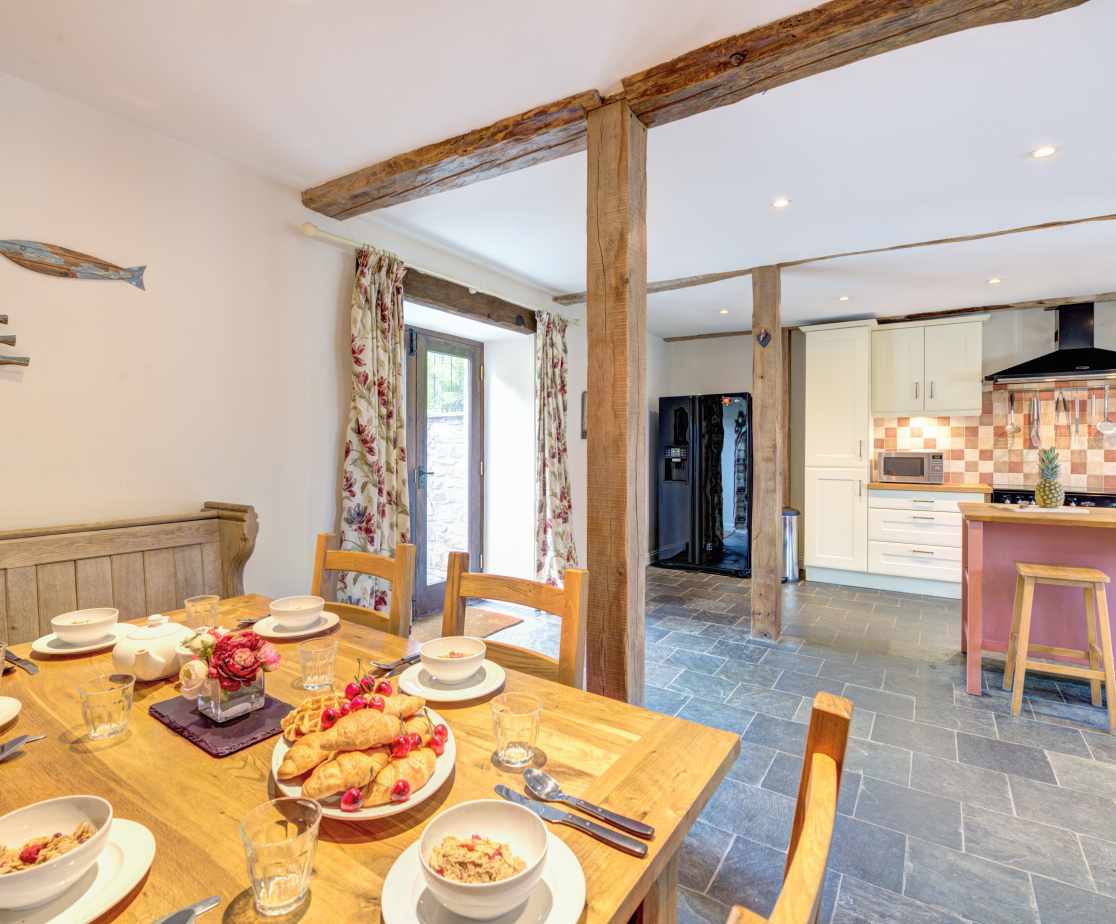 The kitchen is full of character with beams and a slate floor