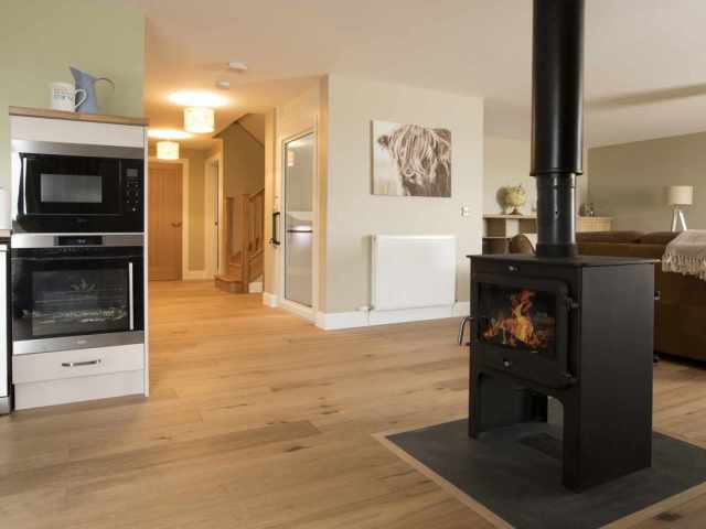 Luxury Perthshire Farmhouse, open plan kitchen, sitting and dining with double sided woodburner